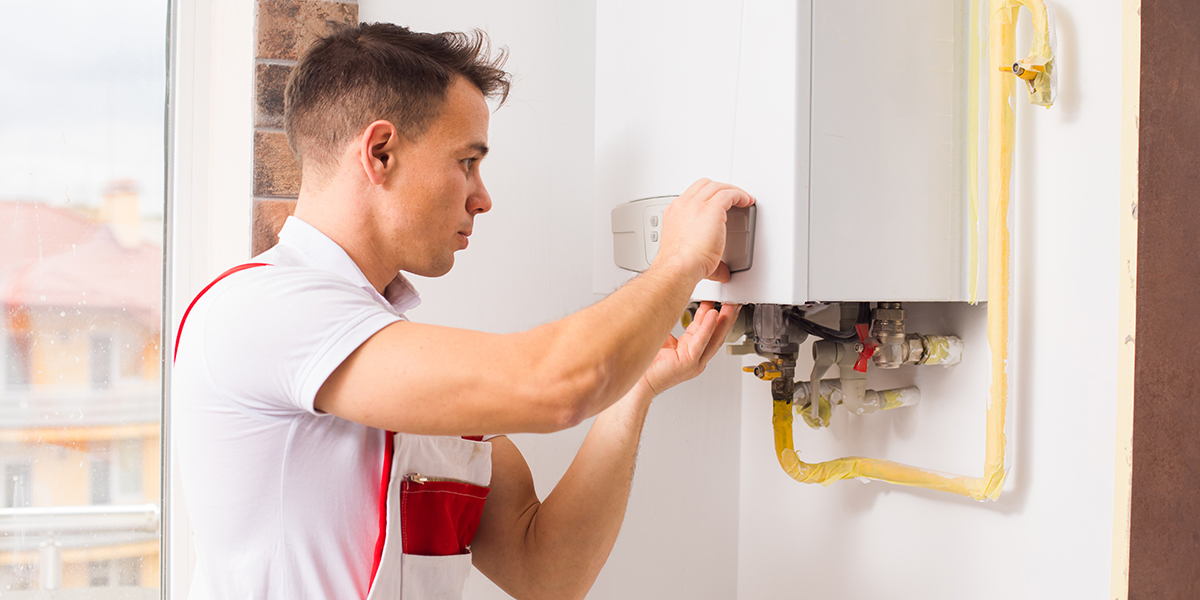 Repair man fixing furnace with wrench